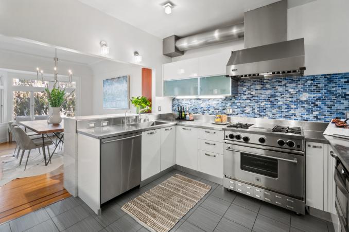 Property Thumbnail: Kitchen has darker gray large tile floor with all white cabinetry. Counter tops are stainless steel. 