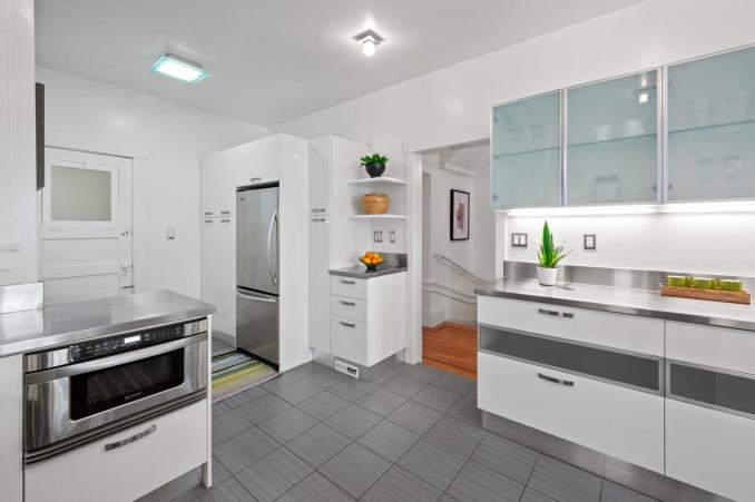 Property Thumbnail: Looking at backside of kitchen. There is a built in stainless microwave and stainless fridge. 