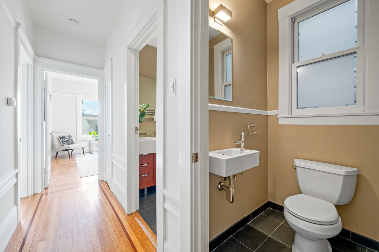 Property Photo: Looking in to updated half bath. There is a window with frosted glass above toilet.
