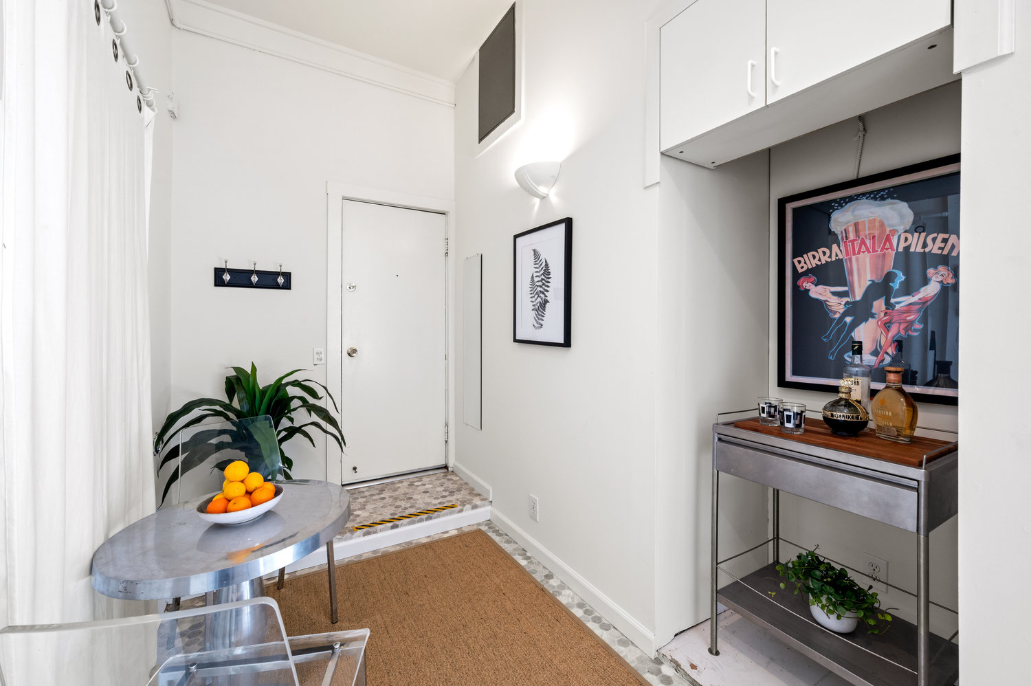 Property Photo: Entryway to bonus space. There is small storage space to right and small table for two on the left. 