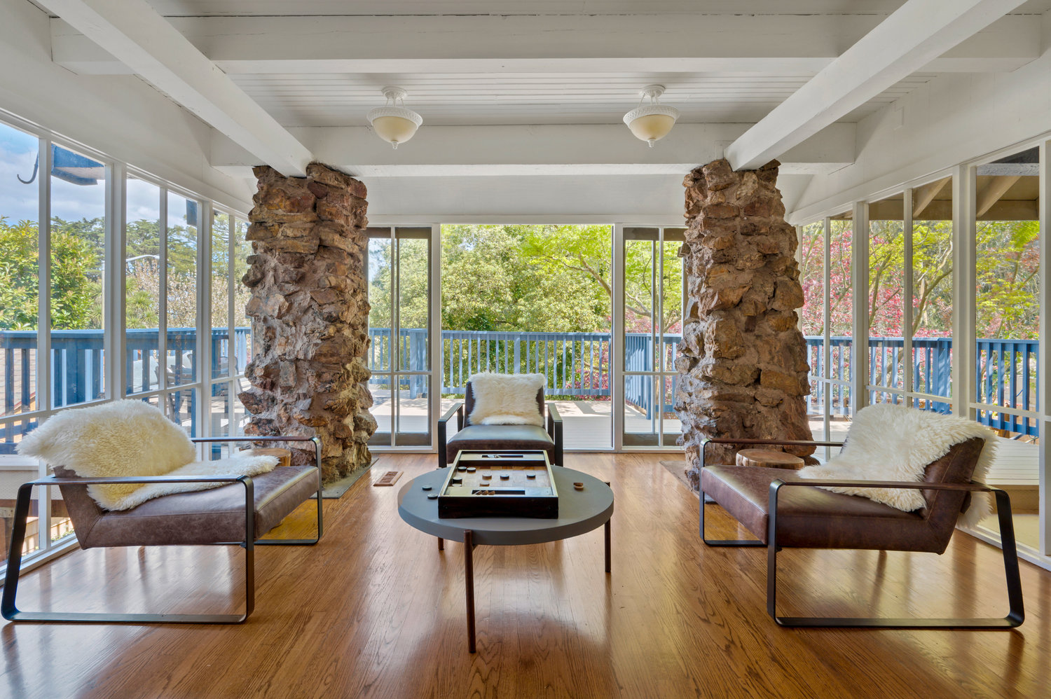 Property Photo: Sitting area that is surrounded by glass windows and french doors that open out to deck. 