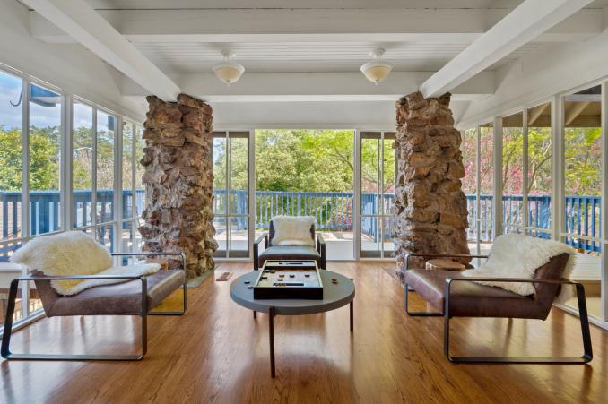 Property Thumbnail: Sitting area that is surrounded by glass windows and french doors that open out to deck. 