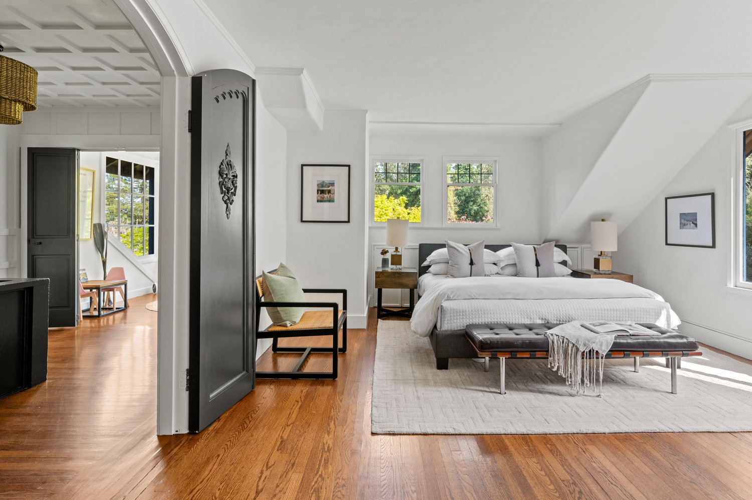 Property Photo: Large bedroom that has king size bed and grand, large, wooden doors that are rounded at the top. 