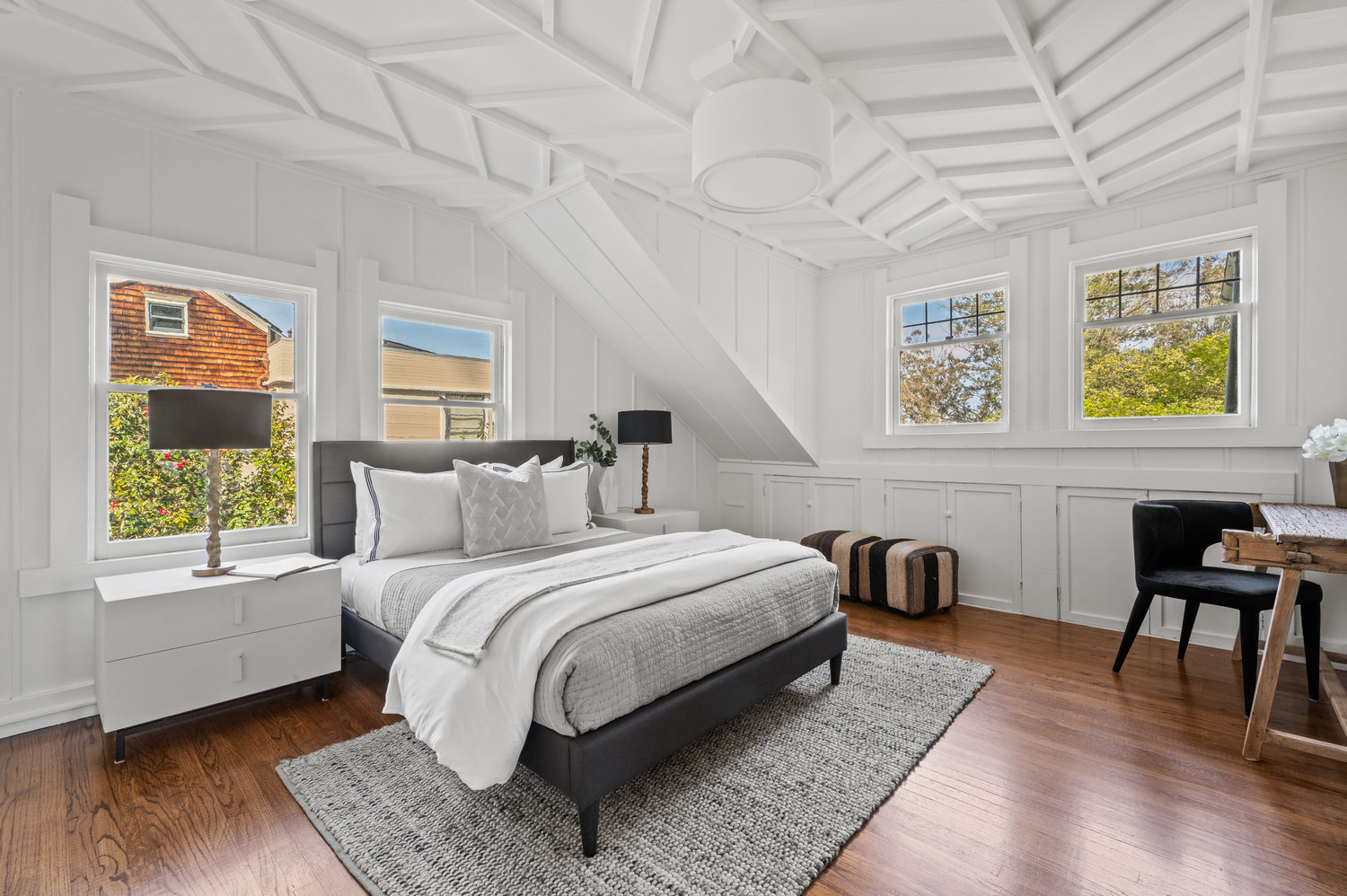 Property Photo: This guest room has stunning chevron wood detailing on the ceiling. There is a queen bed with two bedside tables. 