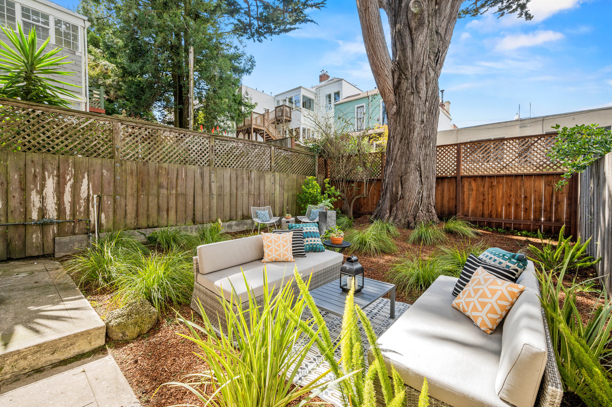 Property Photo: Looking at yard from entry of bonus space. There is a nice sitting area and is well manicured with greenery and wood chips. C
