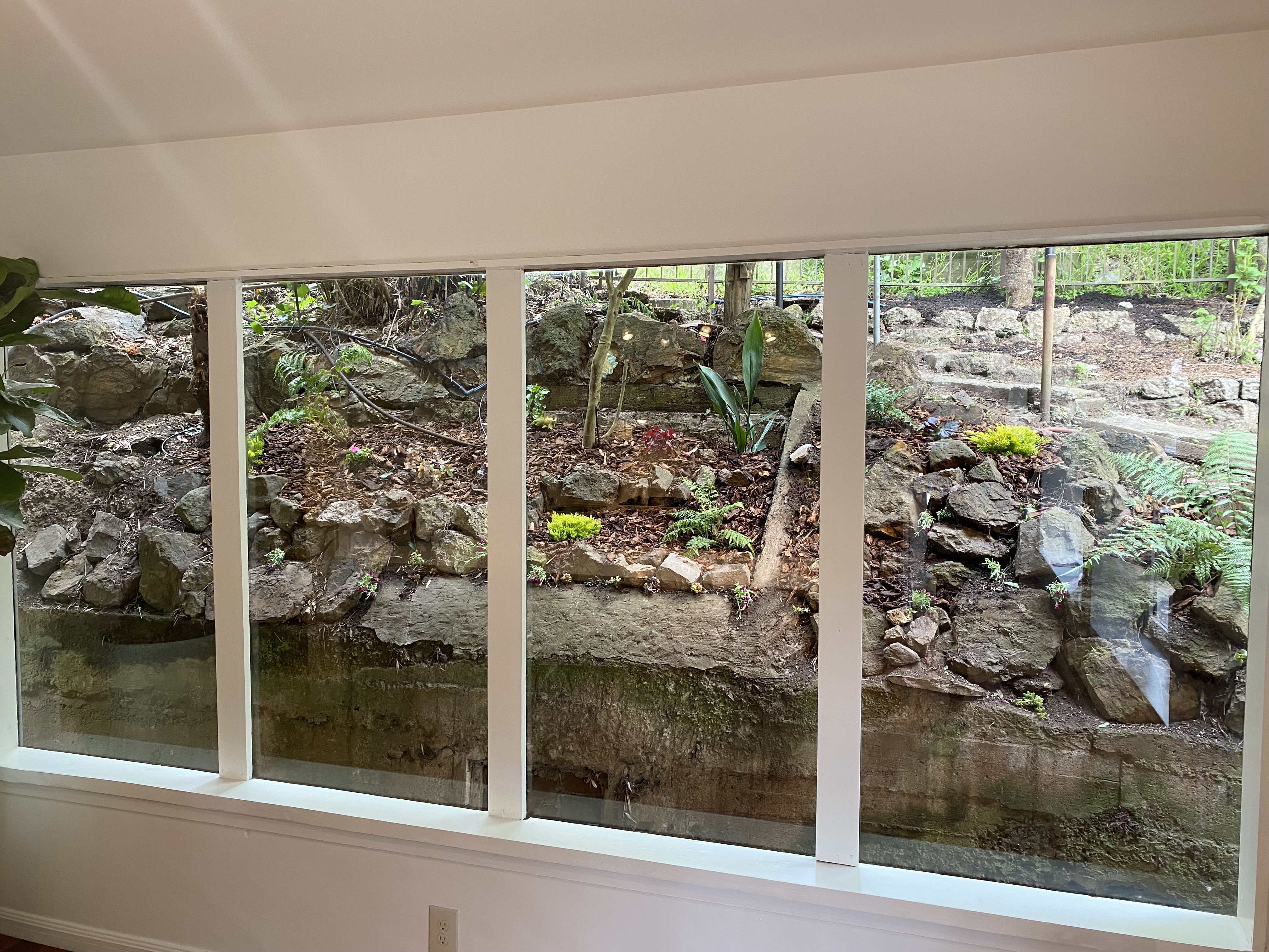 Property Photo: Photo of windows in kitchen that look out to the rocky hill behind the home. 