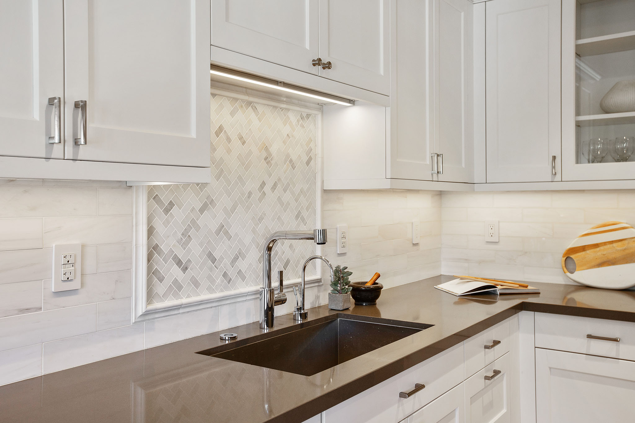 Property Photo: Kitchen sink has chevron tile detail backsplash. 