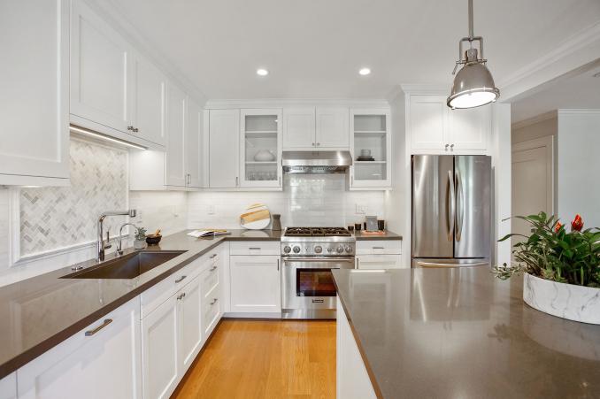 Property Thumbnail: Upper cabinets on both sides of stove hood have see through glass doors. All other cabinet doors are white wood. 