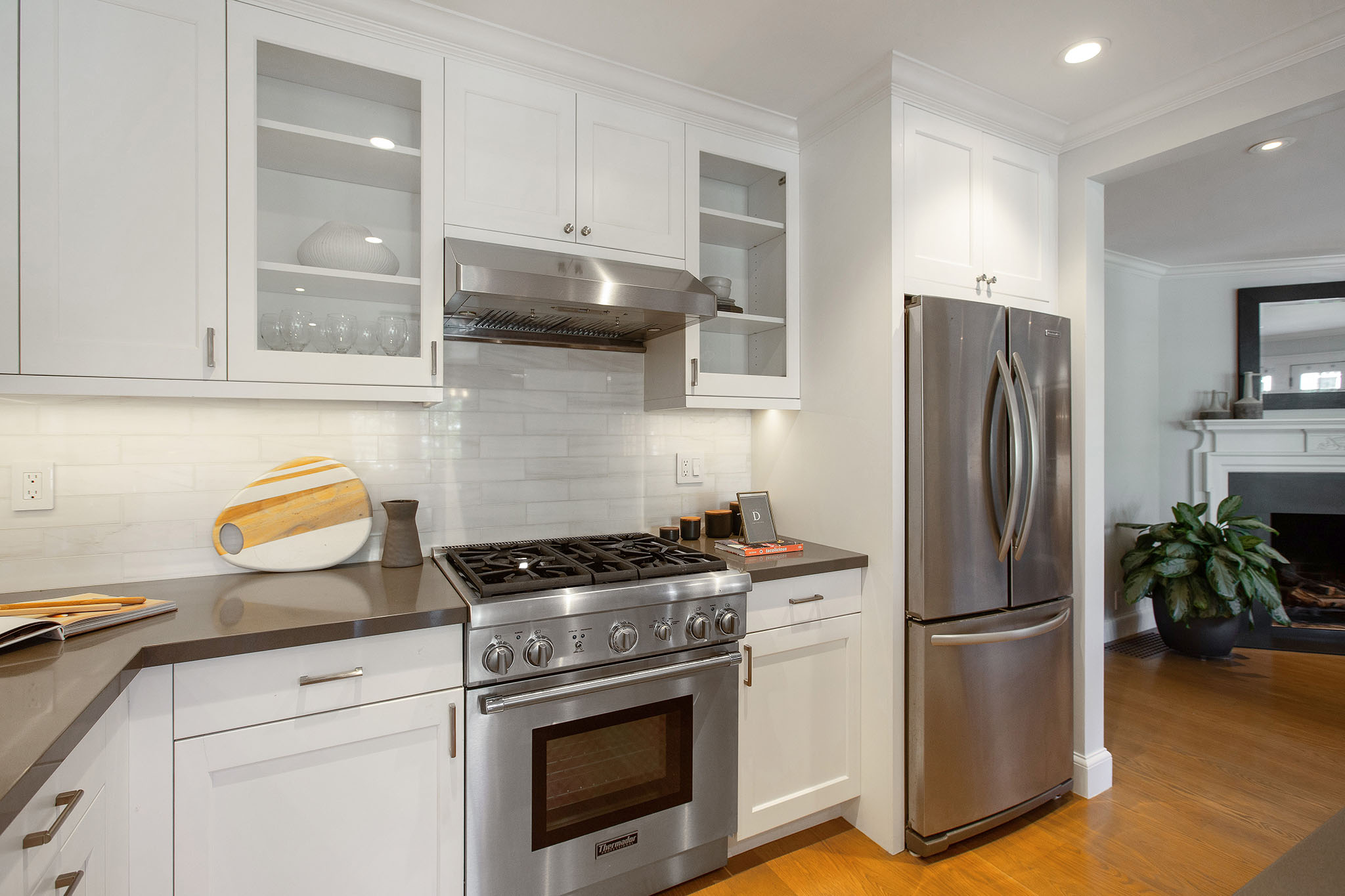 Property Photo: There is a stainless steel gas 4 burner stove with large stainless fridge to the right. 
