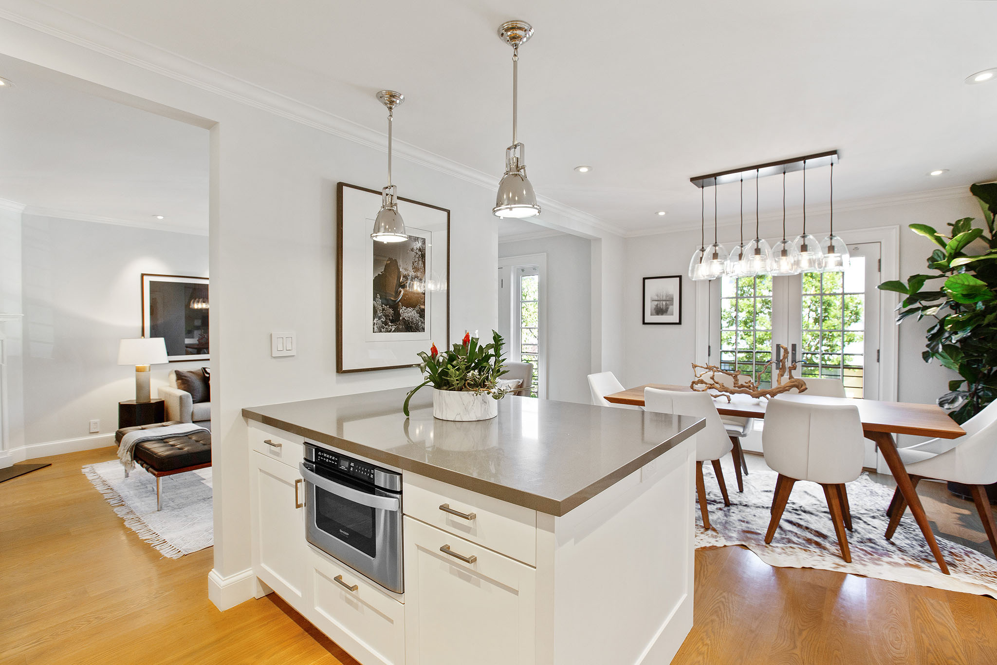 Property Photo: Photo looking over kitchen island with dining space to the right and main entry to the left. 