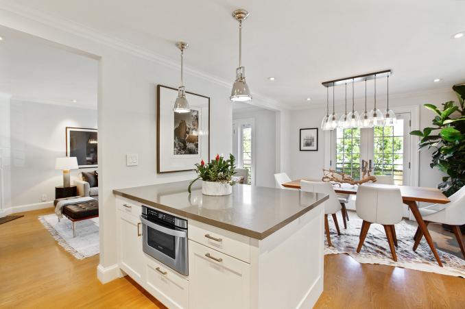 Property Thumbnail: Photo looking over kitchen island with dining space to the right and main entry to the left. 