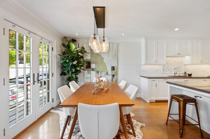 Property Thumbnail: Looking over dining room table from living room. There is a large dining table that seats six. Glass french doors the left and kitchen is the right. 