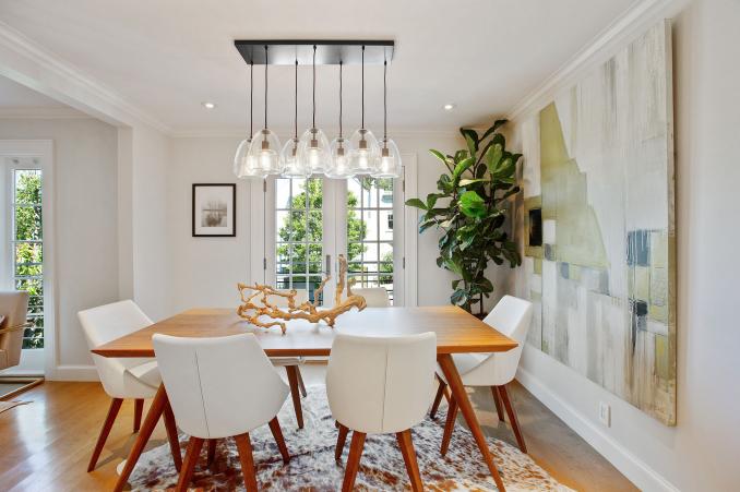Property Thumbnail: Centered photo of dining table. There is a modern glass light fixture above dining table. 