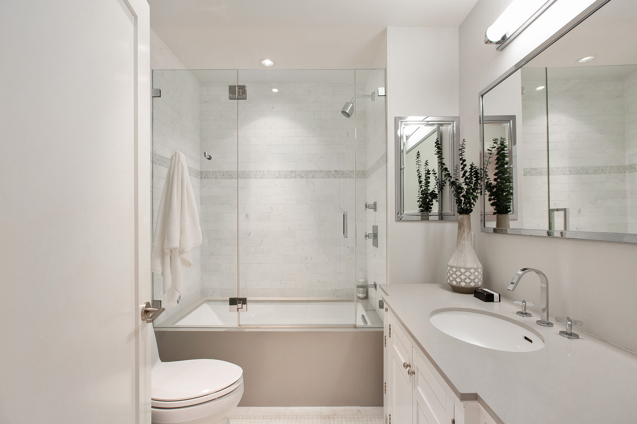 Property Photo: First bathroom has a tub/shower combo. There is one sink and grey countertops. 