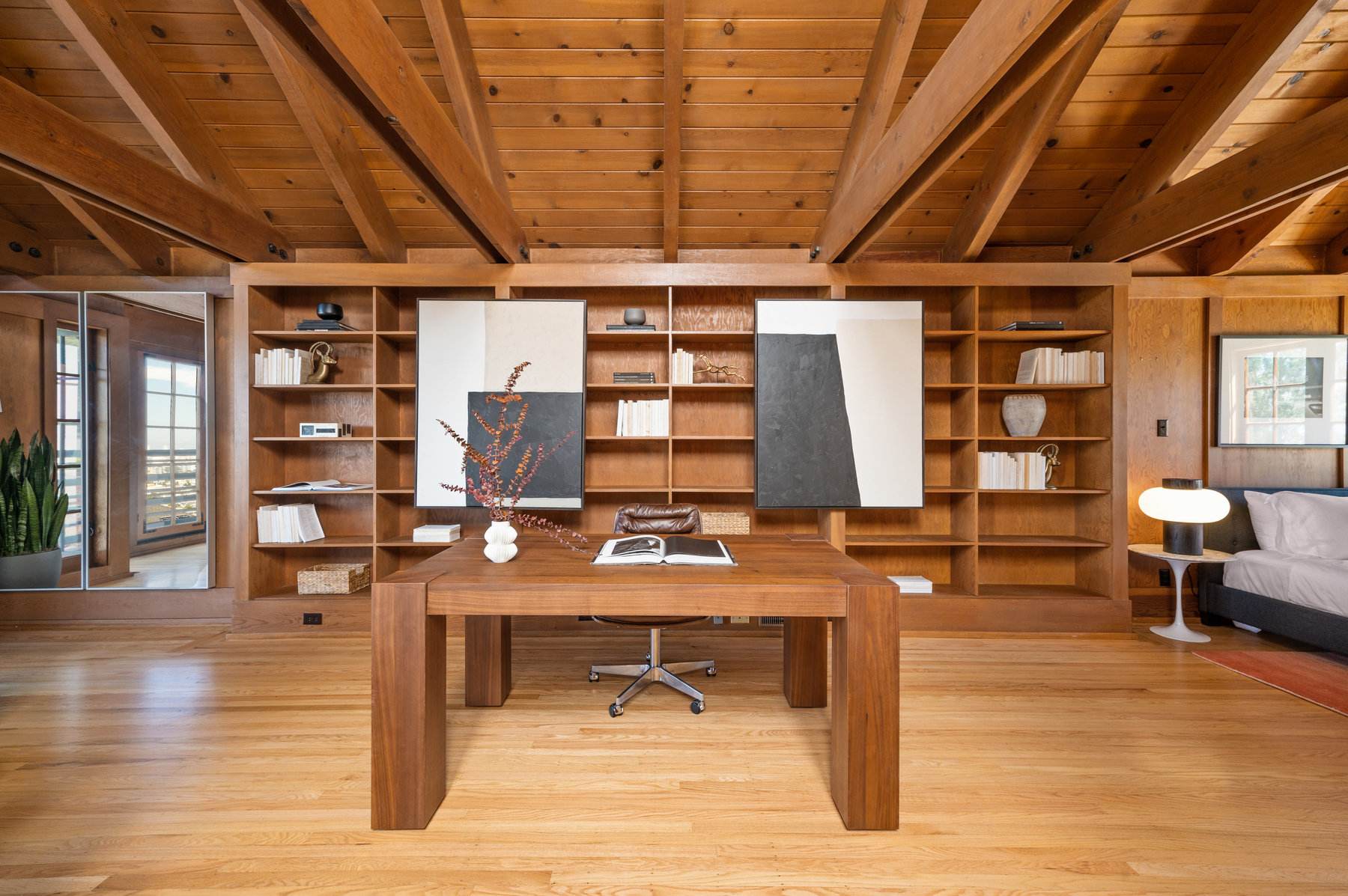 Property Photo: A centered office photo. Large floor to ceiling built in bookshelf fills wall behind desk. Hardwood floors through out. 