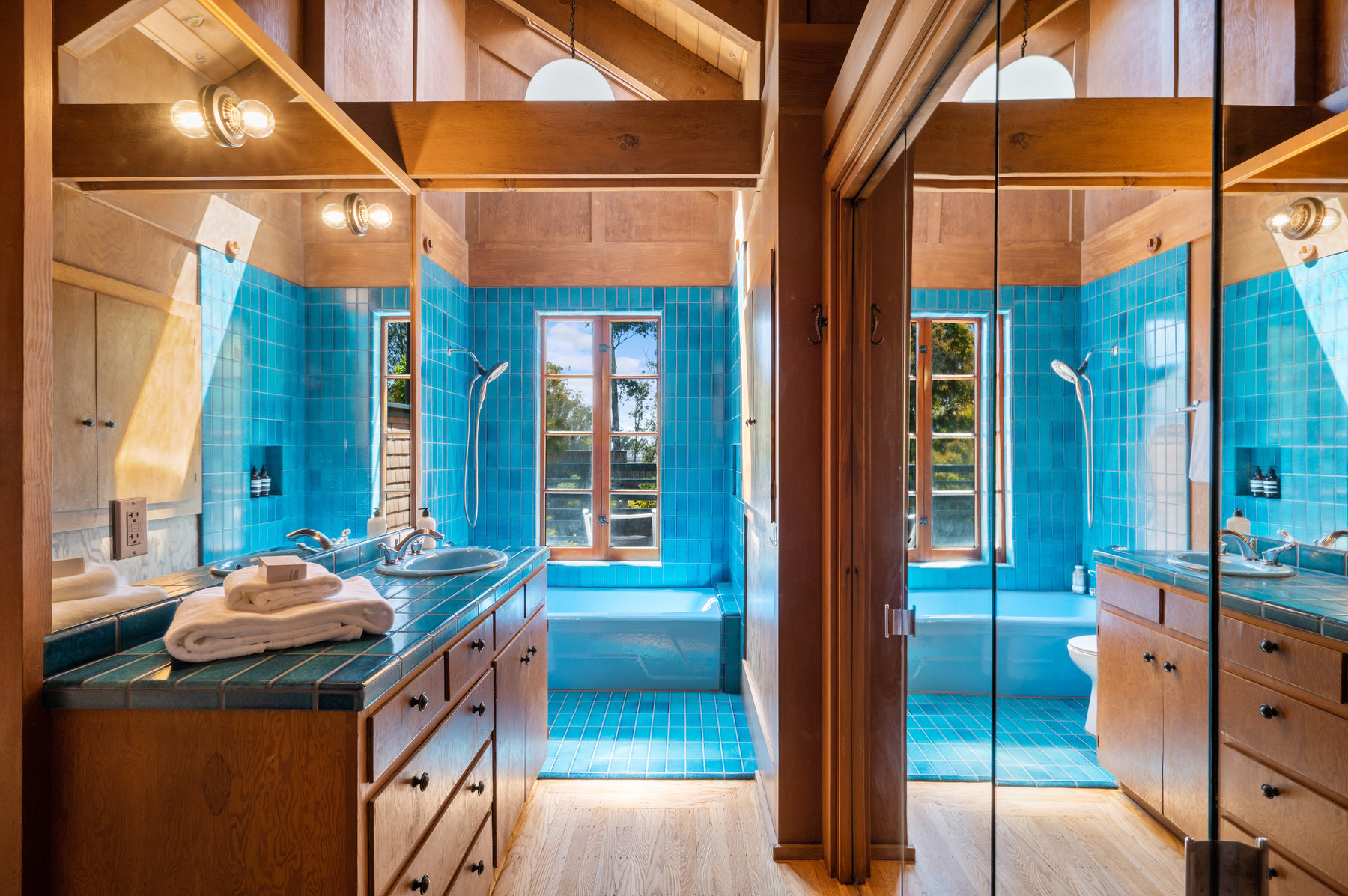 Property Photo: Upper level bathroom that has stunning teal blue Heath Tile on counter top and shower. Large window over tub that looks out to back yard. 