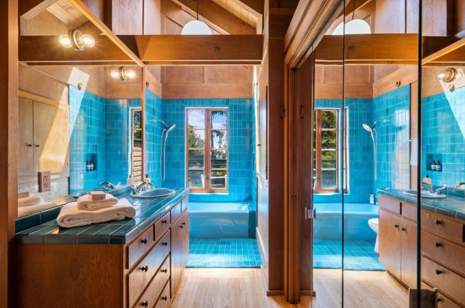 Property Thumbnail: Upper level bathroom that has stunning teal blue Heath Tile on counter top and shower. Large window over tub that looks out to back yard. 