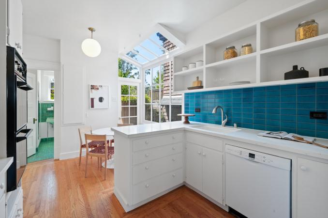 Property Thumbnail: Kitchen has stunning teal Heath Tile backsplash with white counter top and cabinets.