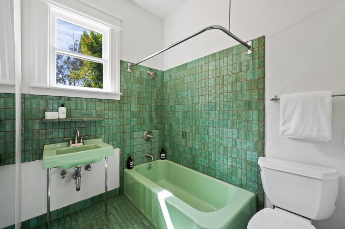 Property Thumbnail: Guest bathroom has green Heath Tile floors and wall around tub and sink. 