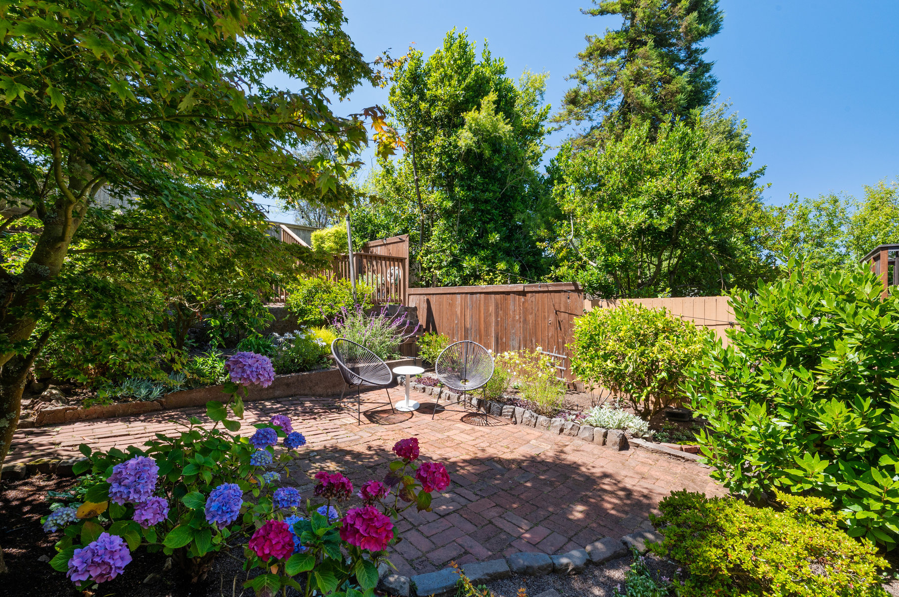 Property Photo: Back yard is fences in and has small sitting area in the middle. 