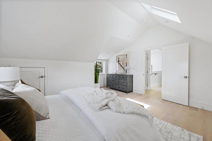 Property Thumbnail: Looking over bed in primary to the doorway. There is a skylight. 