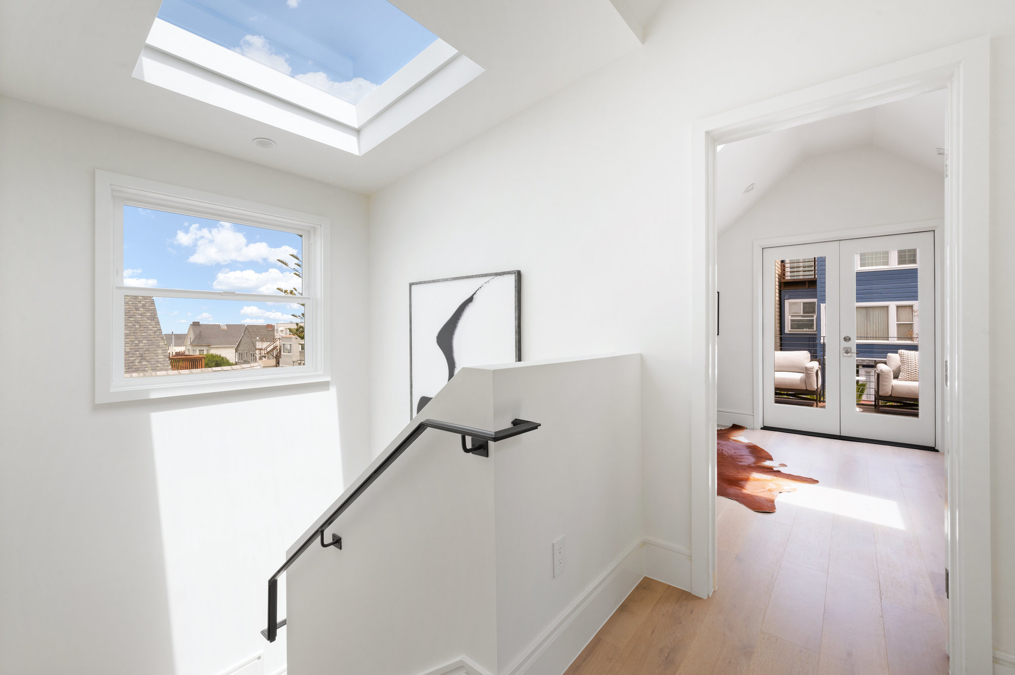 Property Photo: At top of staircase going to upper level there is a skylight and window. 