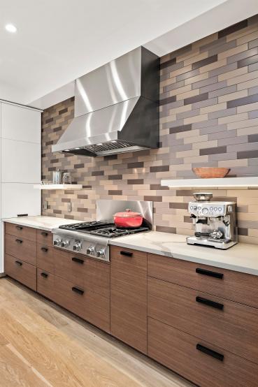 Property Thumbnail: Gas stove is centered on back wall with with large stainless hood and tile backsplash detail. 