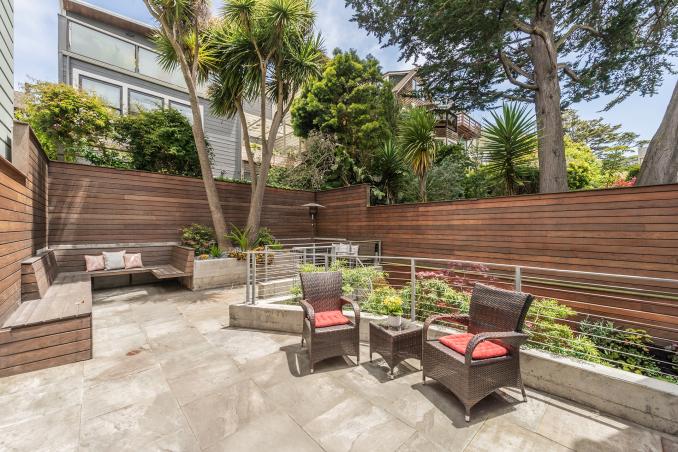 Property Thumbnail: Yard in fenced in with wood fence. There are multiple seating areas and tile flooring. 