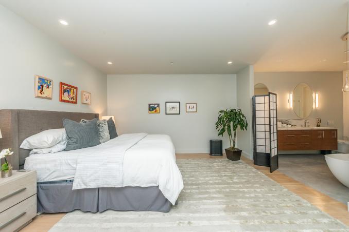 Property Thumbnail: There is a large king bed to left and bathroom that is open to room is on the right. 