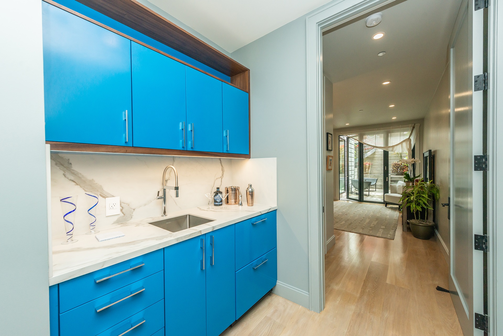 Property Photo: The built in wet bar on lower lever. Bright blue cabinetry with white counters and small stainless sink. 