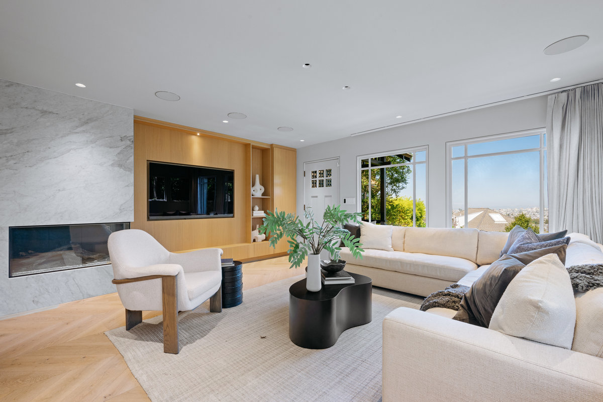 Property Photo: Living room has built-in tv and electric fireplace. There is a large L-shaped couch and plush chair.