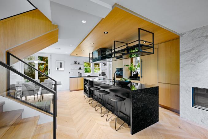 Property Thumbnail: Kitch has large island that has stove, sink, and dishware built in. Countertops are all black stone.