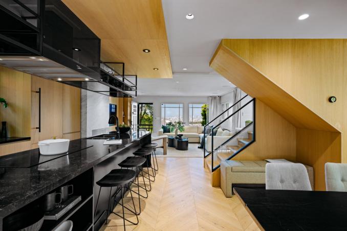 Property Thumbnail: Looking past kitchen to the front living room. There is a staircase to the right.