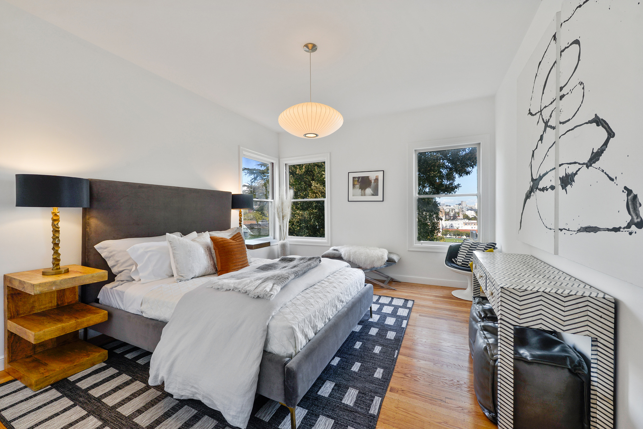 Property Photo: Large bedroom with three windows and wood floors