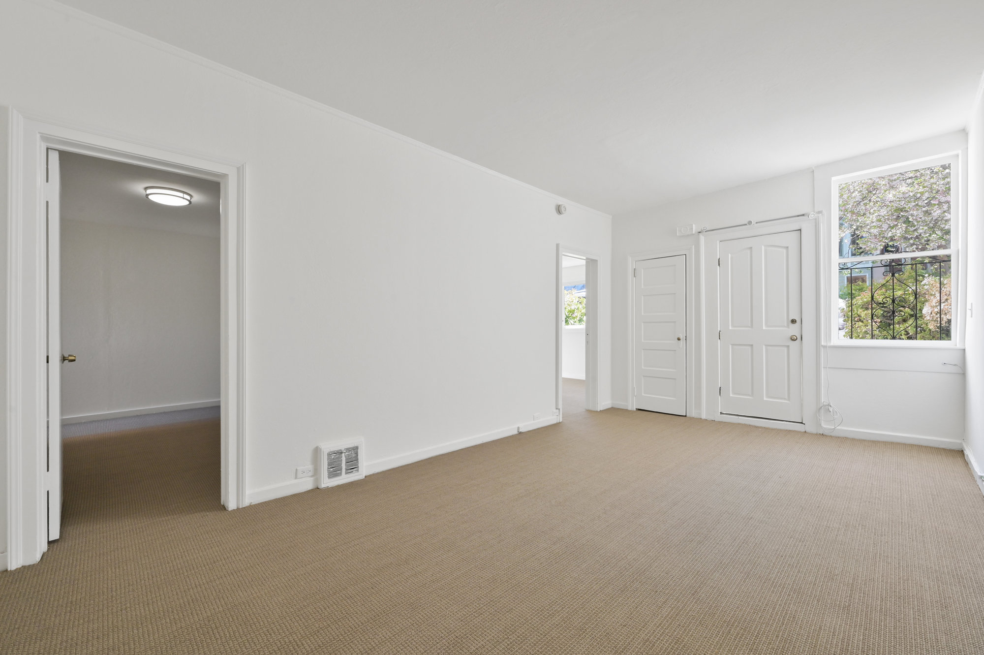 Property Photo: View of a long room with large window and carpeting