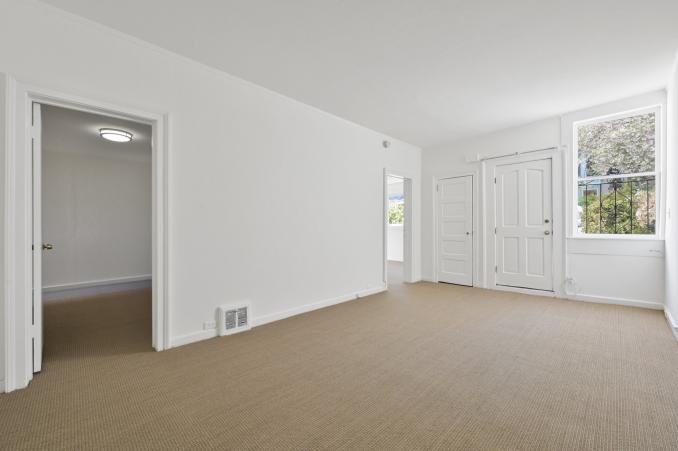 Property Thumbnail: View of a long room with large window and carpeting