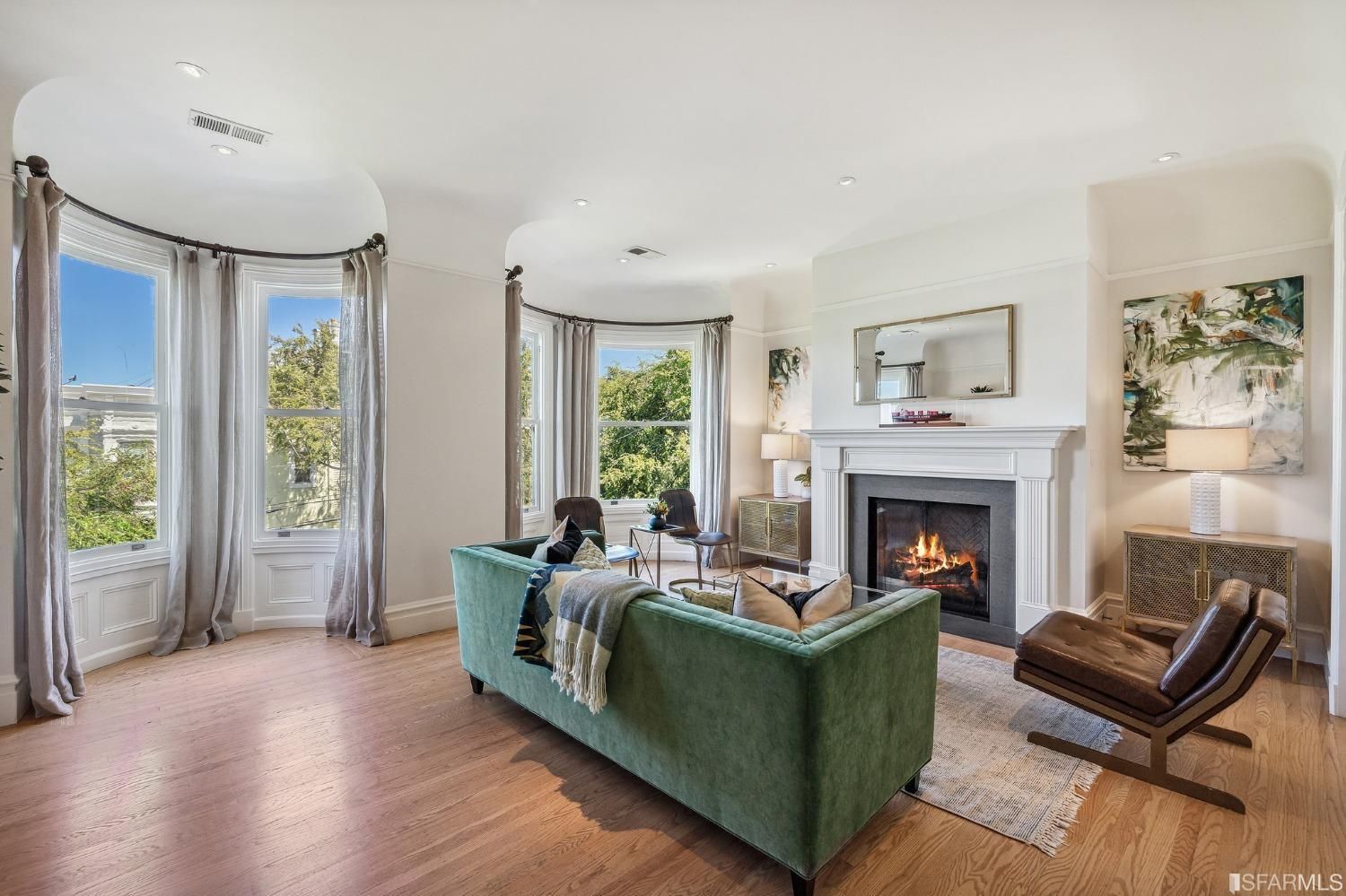 Property Photo: Living room at 286 Fair Oaks St, showing two large bay windows and a large fireplace