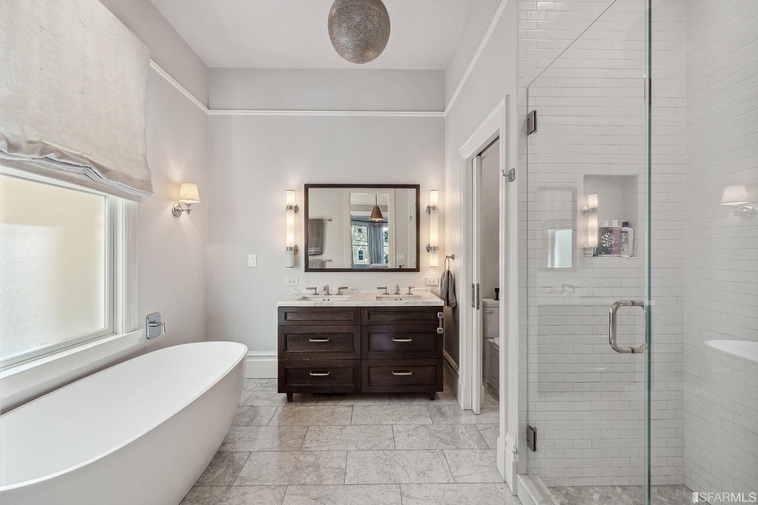 Property Photo: Primary ensuite, featuring a large free-standing bath tub, glass shower, and double vanity