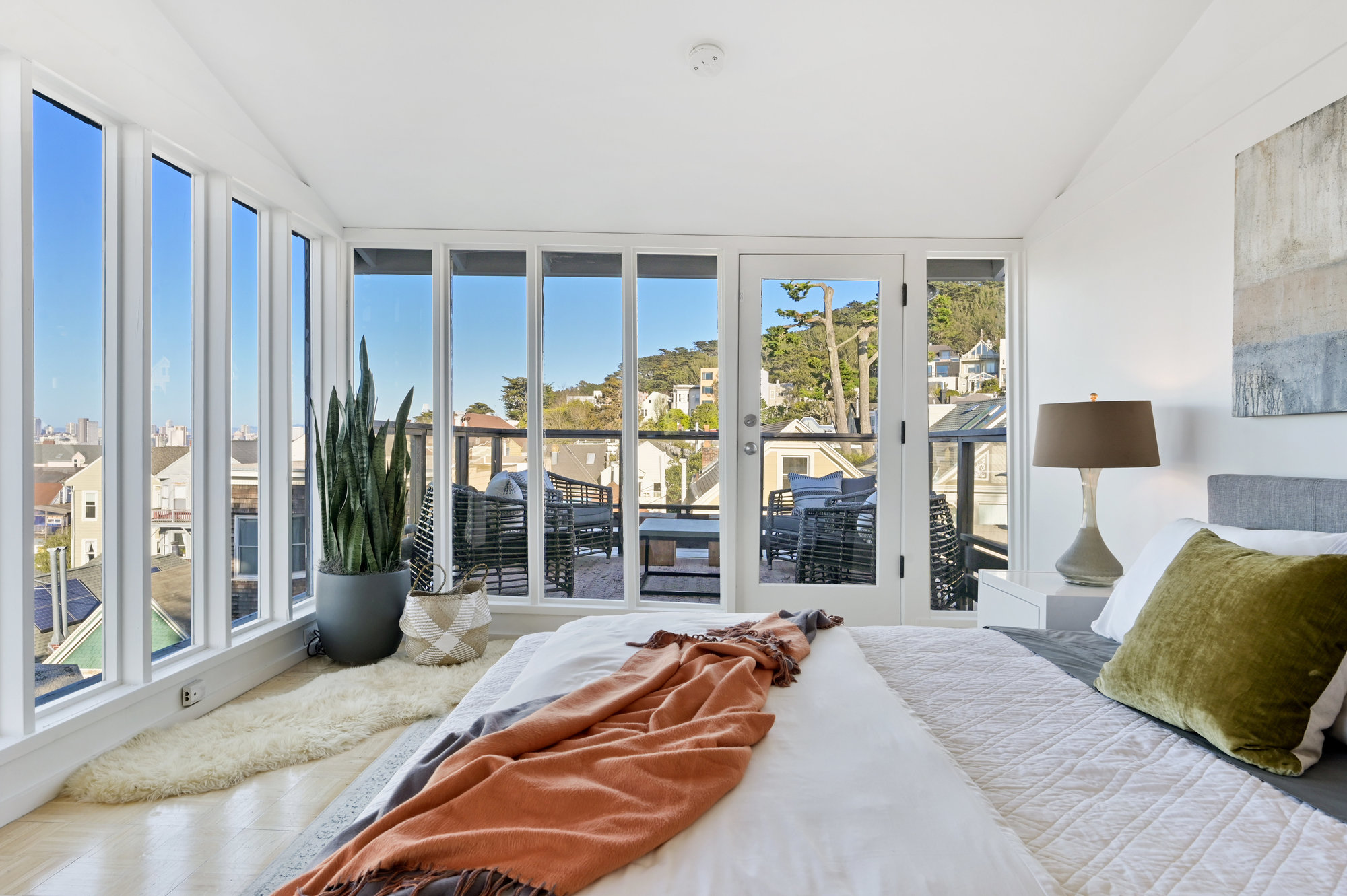 View of a bedroom with wrap-around windows overlooking San Francisco