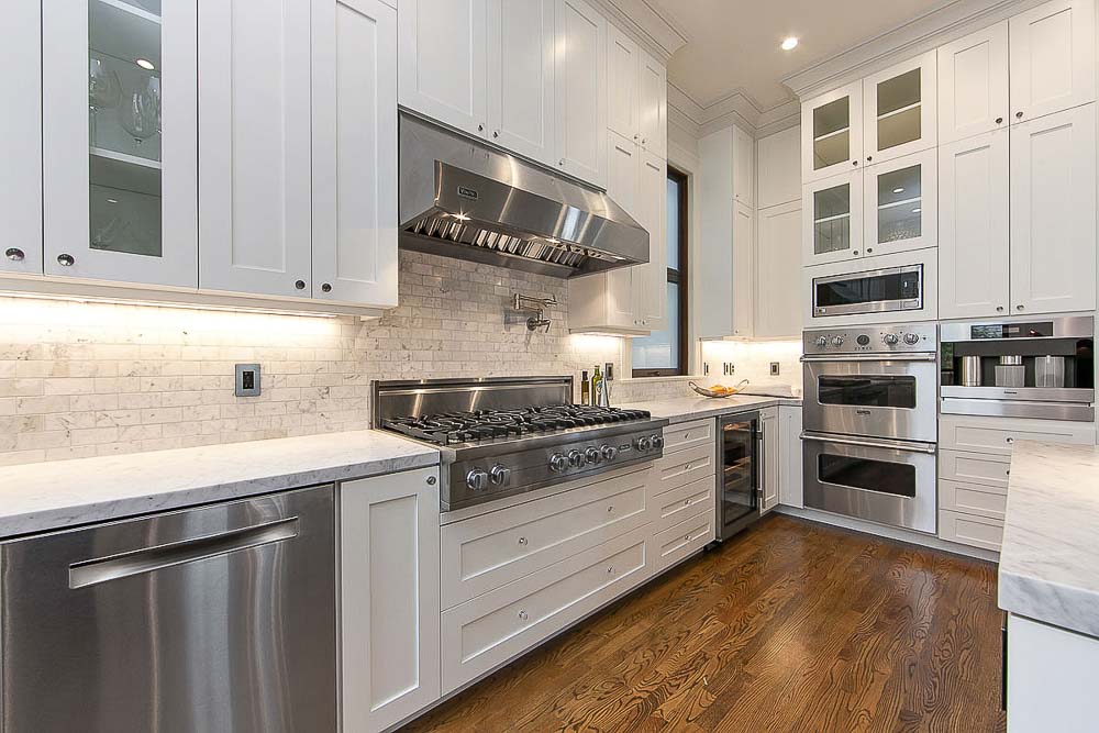 Property Photo: Kitchen with white cabinets and wood floors