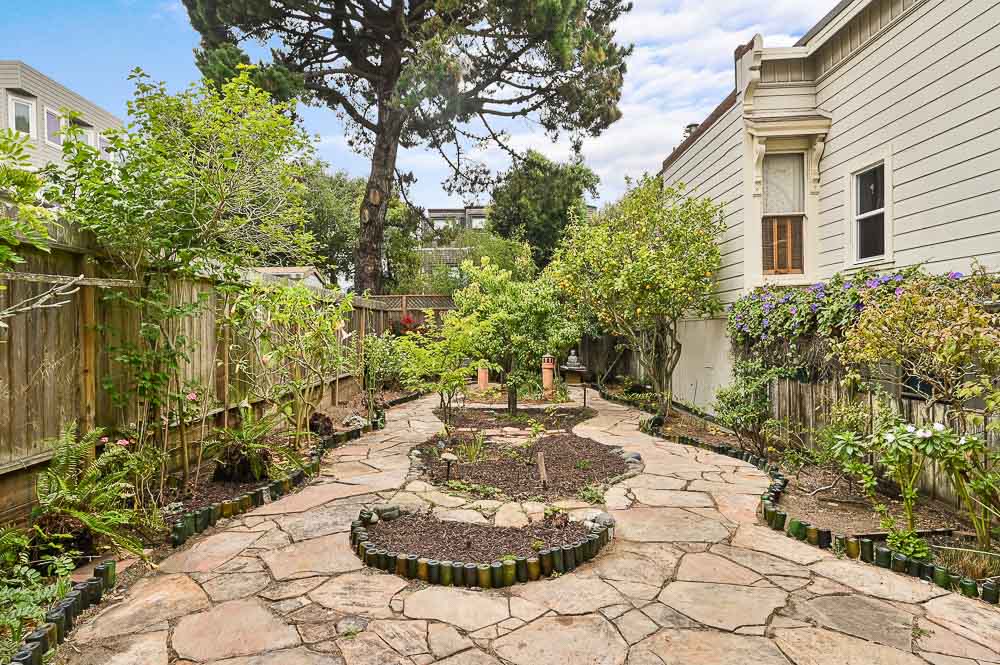 Property Photo: A stone path with lush landscaping 
