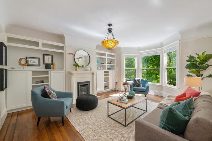 Property Thumbnail: View of the living room at 1056 Cole Street, featuring a fireplace, built-in shelves and bay window