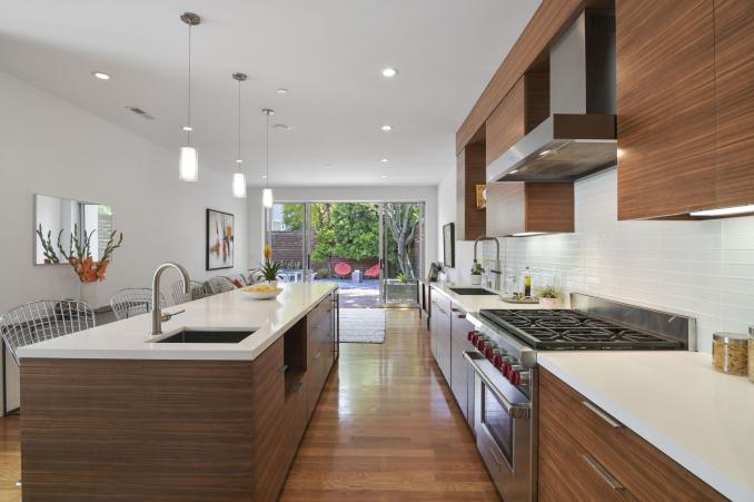 Property Thumbnail: View of the lower unit kitchen, featuring wood floors and an island 