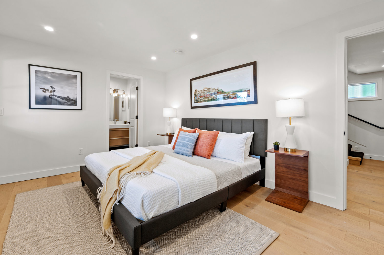 Property Photo: Primary bedroom, featuring wood floors and an ensuite bath
