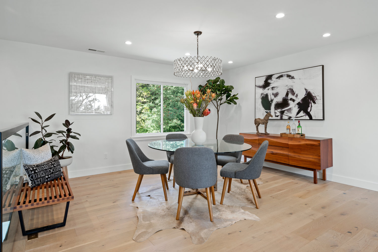 Property Photo: View of the dining area, featuring a mid-century modern light fixture and wood floors
