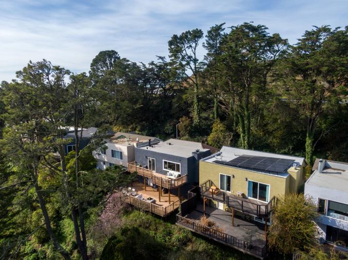 Property Thumbnail: Side aerial view of 156 Midcrest, showing the home surrounded by trees 