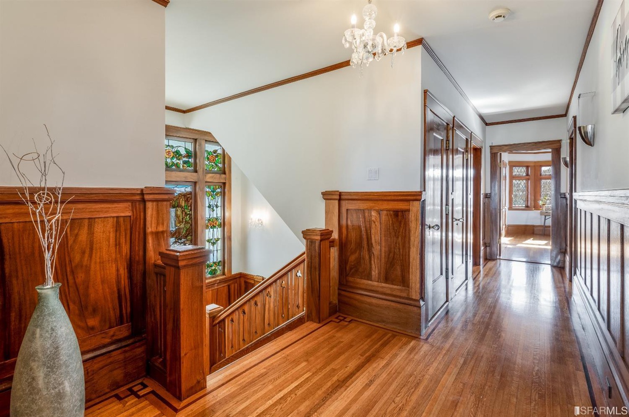 Property Photo: Hallway with wood floors and staircase leading down