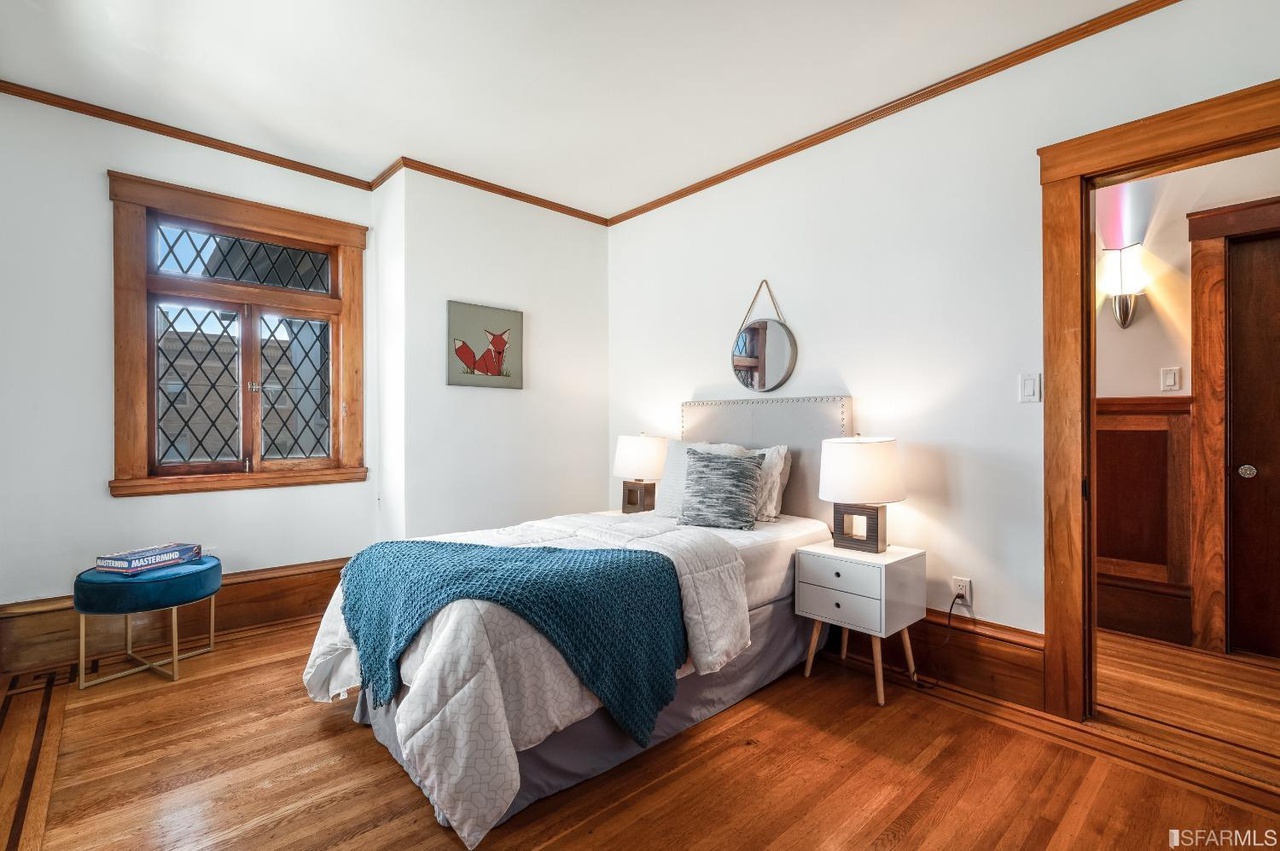 Property Photo: Bedroom three, featuring wood floors and plenty of natural light