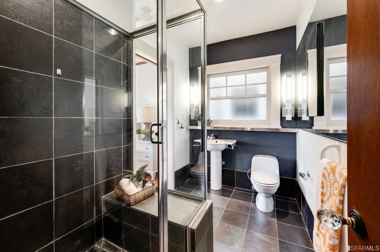 Property Photo: Bathroom with black tile and glass shower