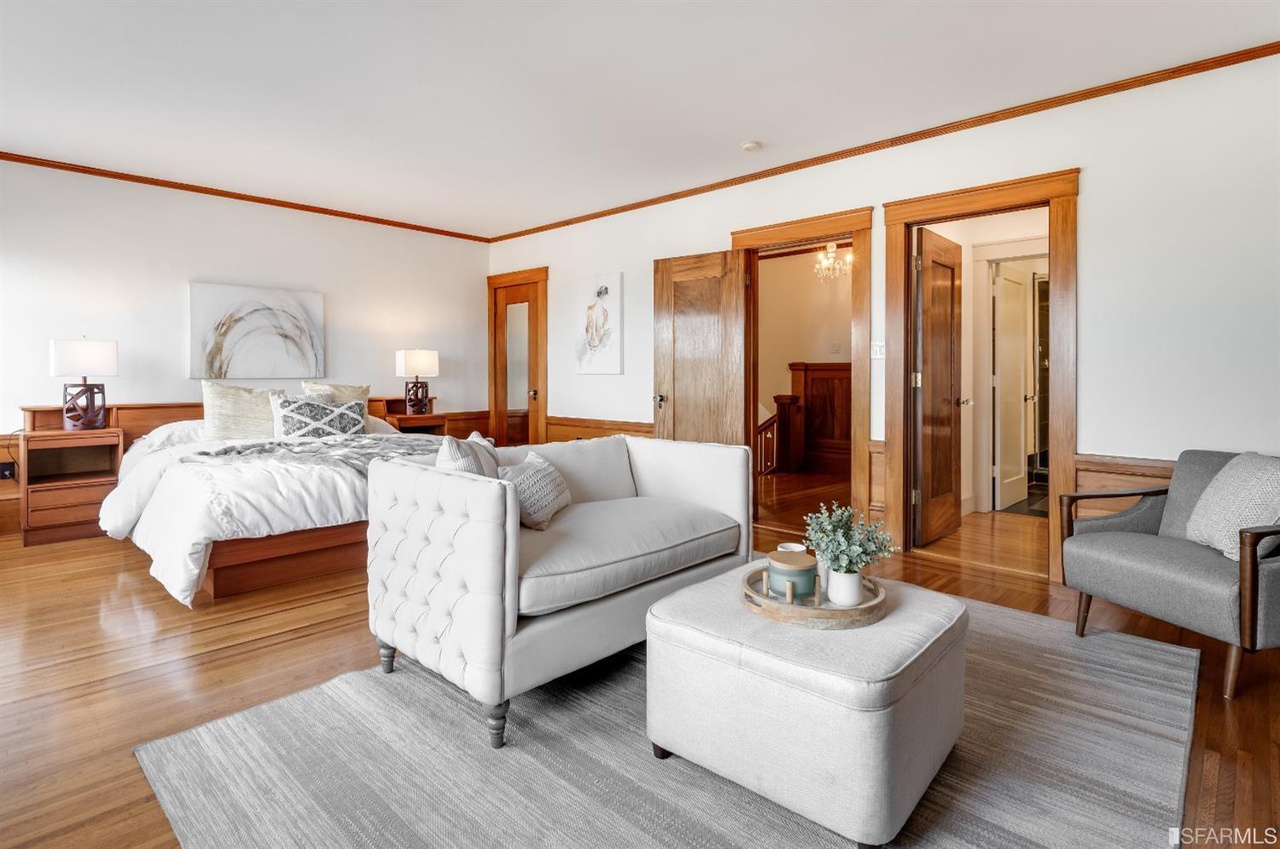 Property Photo: Primary suite, featuring wood floors and a sitting area